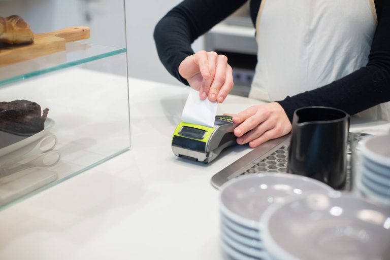 A person rips a receipt at a cafe.