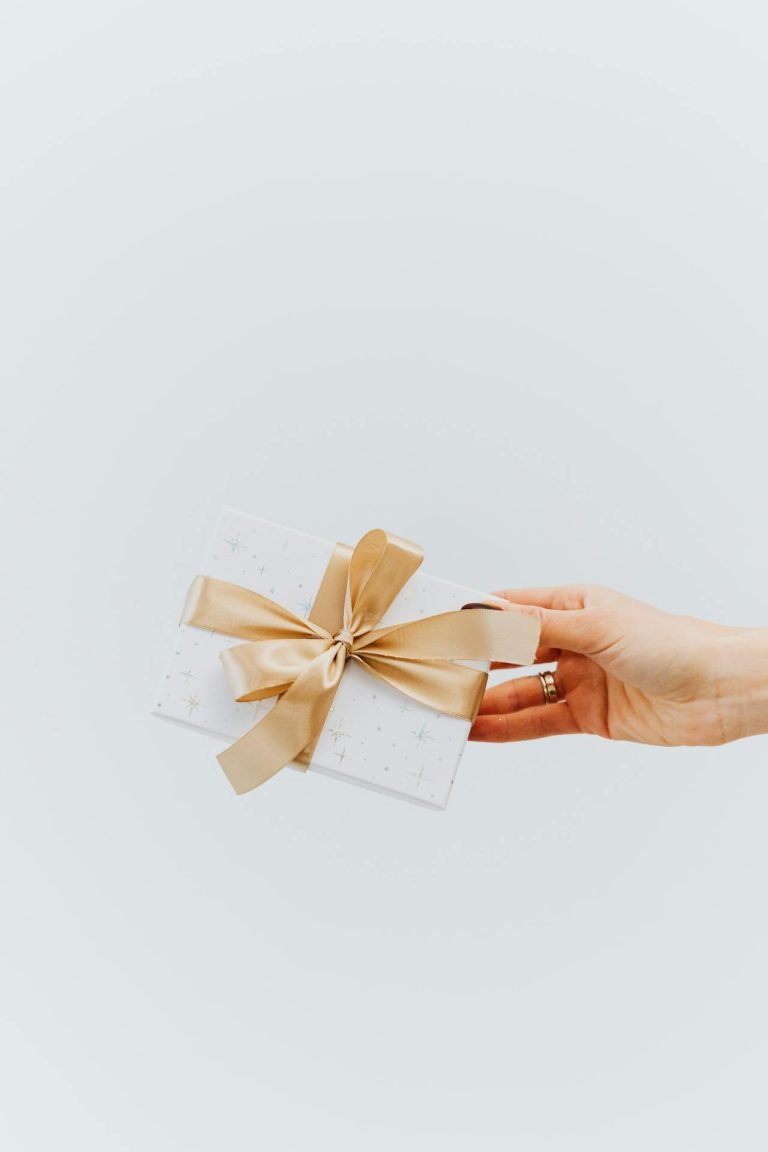 A person handing a card with a bow on it.