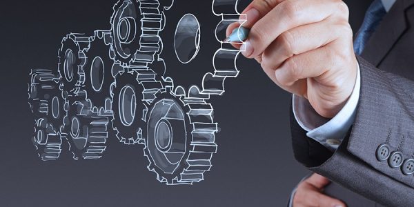 A person in a suit is drawing transparent interlocking gears in the air, symbolizing teamwork or business process concepts within an Agent Program.