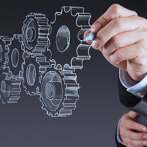 A person in a suit is drawing transparent interlocking gears in the air, symbolizing teamwork or business process concepts within an Agent Program.